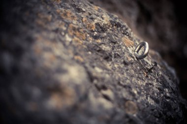 Kaya tırmanışında kullanılan, taşa batırılmış bir metal platformun yakın çekim görüntüsü..