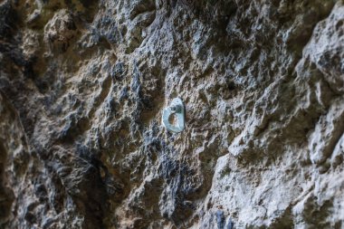 Kaya tırmanışında kullanılan, taşa batırılmış bir metal platformun yakın çekim görüntüsü..