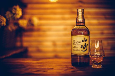 Bükreş, Romanya - 25 Şubat 2021: Romanya 'nın Bükreş kentinde tek malt malt Japon viski şişesi ve Glencairn viski bardağının resimli editörlüğü.