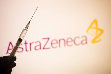 Bükreş, ROMANIA - 15 Mart 2021: Arkaplanda AstraZeneca logosu bulunan bir doz Coronavirus COVID-19 aşısı içeren illüstrasyon konsepti resmi.