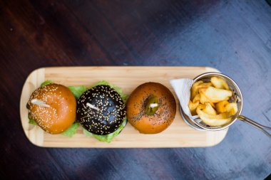 Üç mini burger ve patates kızartması yakın çekim..