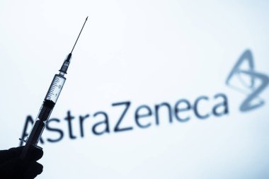 Bükreş, ROMANIA - 15 Mart 2021: Arkaplanda AstraZeneca logosu bulunan bir doz Coronavirus COVID-19 aşısı içeren illüstrasyon konsepti resmi.