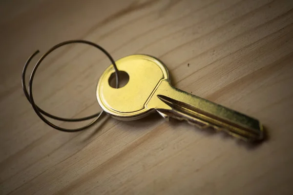 Close up shot of a vintage key on a wooden background.