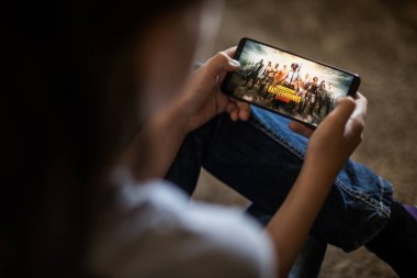 Bükreş, ROMANIA - 10 Mayıs 2021: Cep telefonuyla Battlefield oyunu oynayan bir çocuğun resimli editörlük konsepti.