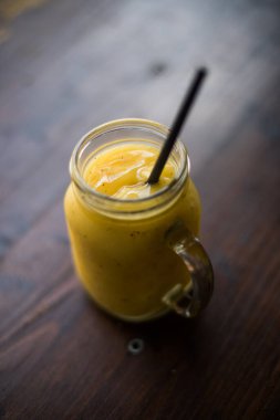 Lezzetli bir meyve püresi ve pipetli cam kavanoz..