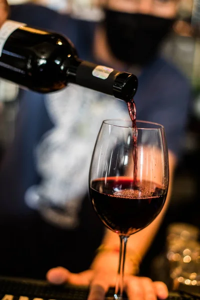 Ein Barkeeper Gießt Etwas Rotwein Aus Einer Flasche Ein Glas — Stockfoto