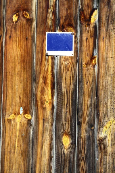 Houten planken met blauw bord — Stockfoto