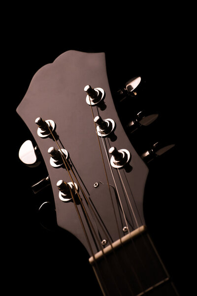 Head stock of a dark solo guitar.
