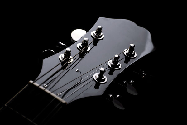 Head stock of a dark solo guitar.