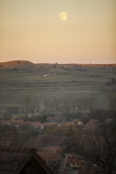 Moonrise over a village — Stock Photo, Image