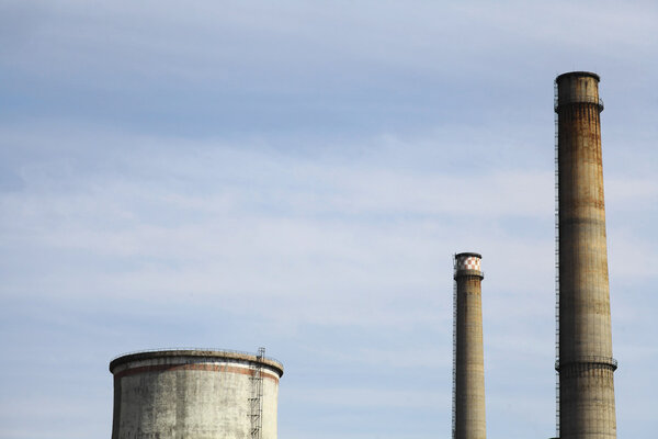 Color image of some chimneys at a factory.
