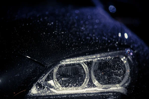 Car headlight with rain drops — Stock Photo, Image