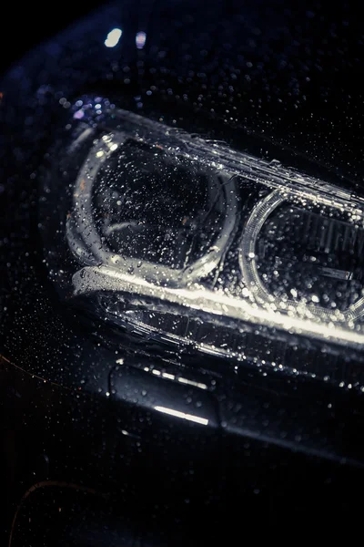 Car headlight with rain drops — Stock Photo, Image