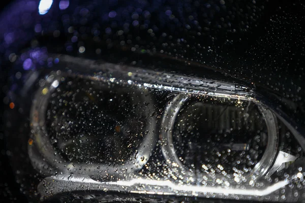 Farol do carro com gotas de chuva — Fotografia de Stock