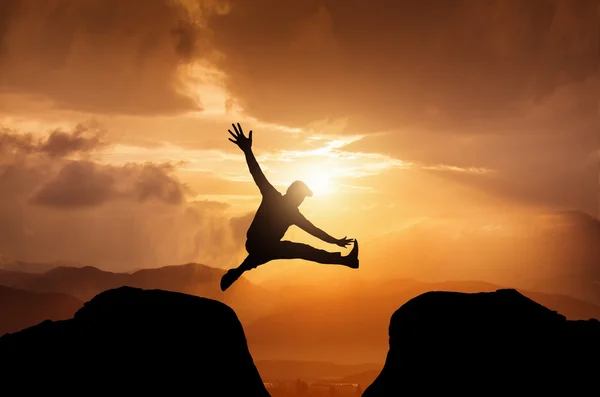 Silhouette eines springenden Mannes auf dem Gipfel — Stockfoto