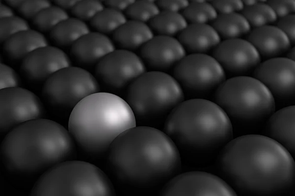 Bola branca diferente entre bolas pretas — Fotografia de Stock