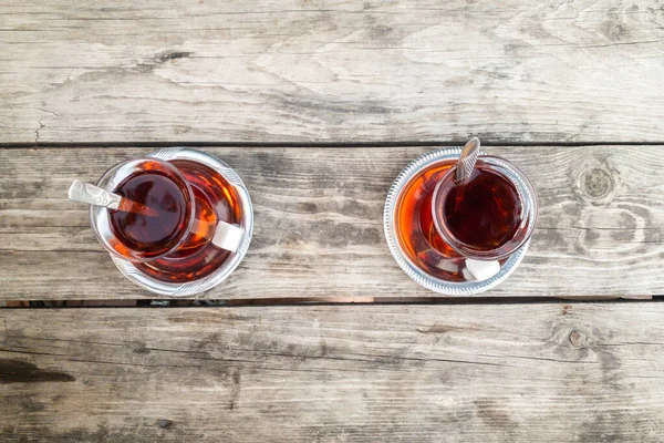 Deux verres de thé isolés sur une table en bois franc brun naturel. Papier peint texturé. — Photo
