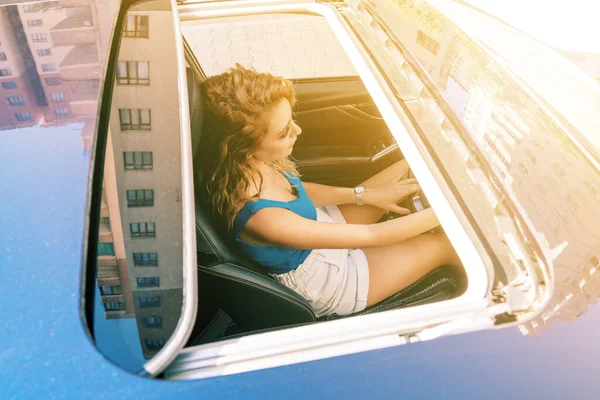 車の座席に座って慎重に運転若い美しい女性のサンルーフからのトップビュー. — ストック写真