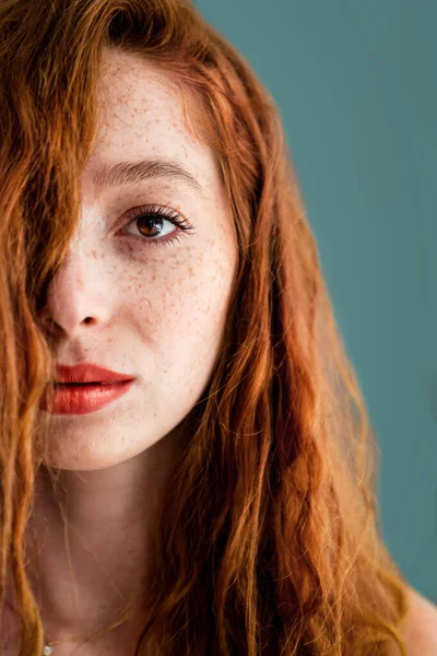 Yeşil arka planda kızıl saçlı ve dudaklı güzel bir kadının yüzü. — Stok fotoğraf