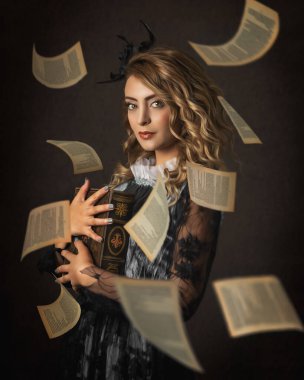 Elinde kitap tutan güzel bir kadının portresi klasik Victoria tarzı kıyafet ve koyu arkaplanda saç stili ile uçan sayfalar.