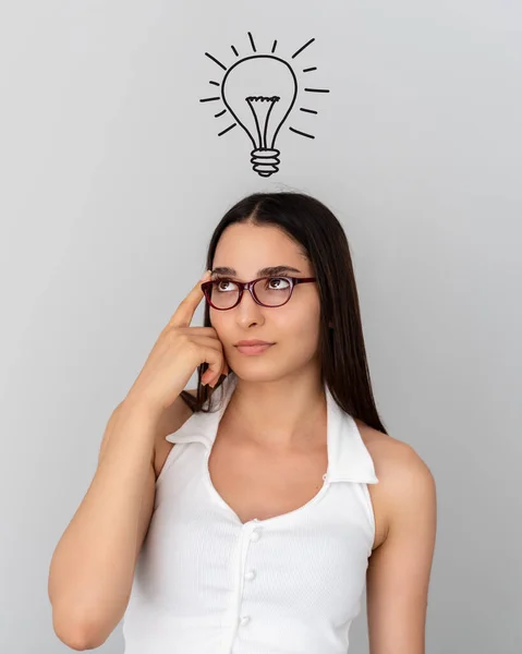 Junge denkende Frau mit abstrakter Glühbirnenzeichnung auf dem Kopf. Idee, Lösung, Konzept — Stockfoto