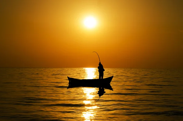 Silhouette da pescatore al tramonto. — Foto Stock