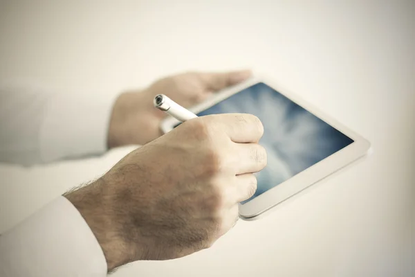 Man holding a white tablet with pen — Stock Photo, Image