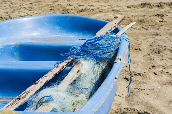 Риболовля Інтернет і синій човен на піску — стокове фото