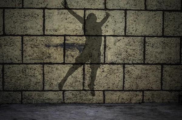 Hombre silueta saltando delante de la pared de ladrillo —  Fotos de Stock