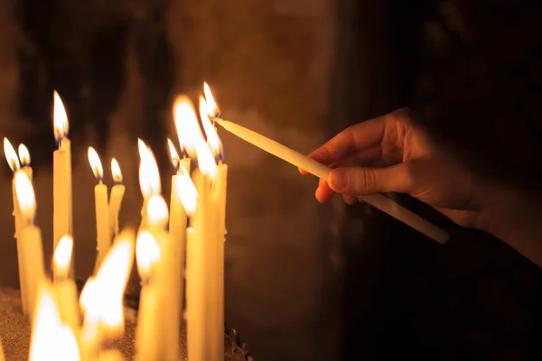 Donna che accende candele in una chiesa — Foto Stock