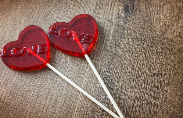 Czerwony cukierki z serca kształcie polewa na drewniane tła — Zdjęcie stockowe