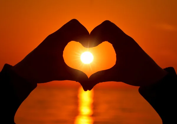 Herzform mit Händen am Sonnenuntergang — Stockfoto