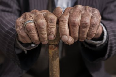 bir baston tutan bir yaşlı adamın elini
