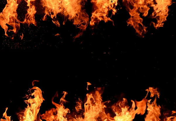 Flammande lågor över svart bakgrund — Stockfoto
