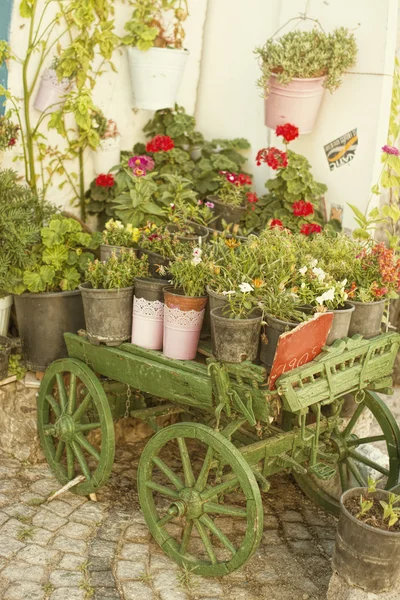 Viejo carro de madera verde lleno de flores — Foto de Stock