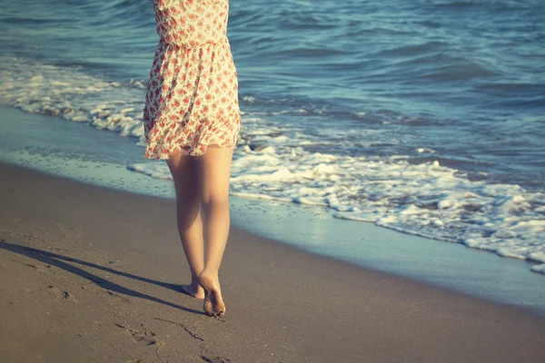 As pernas de uma mulher andando em uma praia — Fotografia de Stock