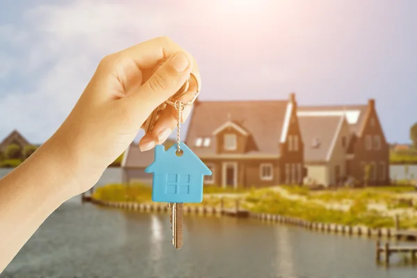 Femme Remise des clés de la maison devant une belle nouvelle maison . — Photo