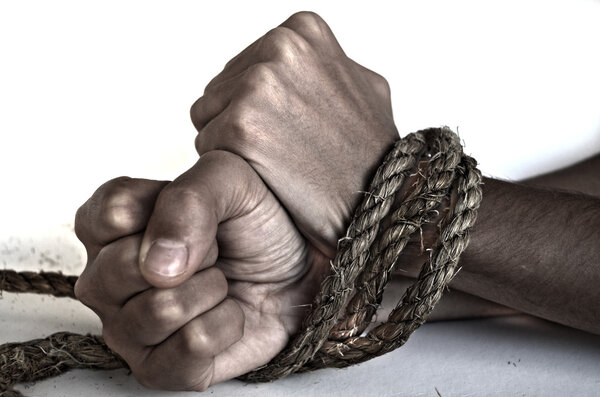 Hands of woman tied up with rope