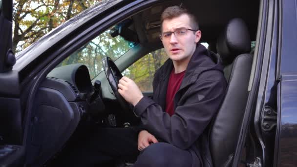 Homem fala para a câmera enquanto sentado em um carro — Vídeo de Stock