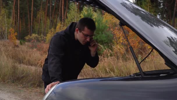 El hombre está en el teléfono en un coche roto — Vídeos de Stock