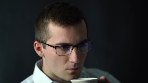Бизнесмен пьет кофе, сидя в офисе — стоковое видео