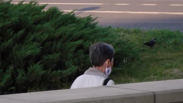 Starsza kobieta nosi maskę na ulicy. — Wideo stockowe