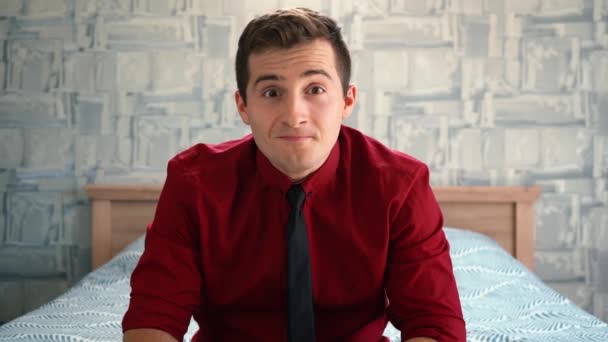 Man in een shirt zit thuis geeft vrolijke emoties — Stockvideo