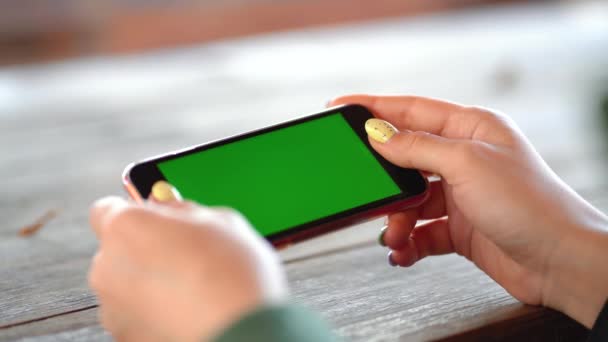 Chica está sosteniendo un teléfono con una pantalla verde — Vídeos de Stock