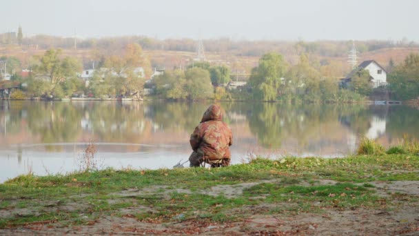 Man zit op een vijver en vangt vis in de vroege ochtend — Stockvideo