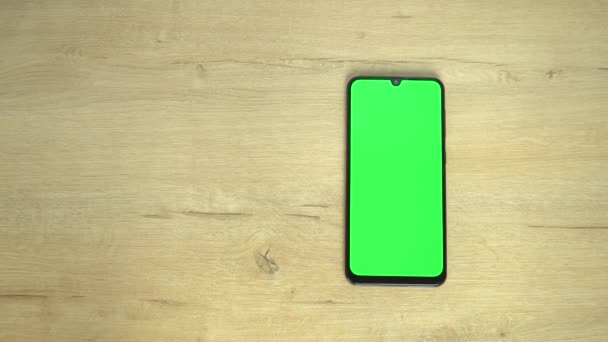 Smartphone con pantalla verde sobre fondo de madera — Vídeos de Stock