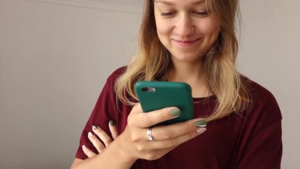 Κορίτσι χρησιμοποιεί το τηλέφωνο και χαμόγελα — Αρχείο Βίντεο