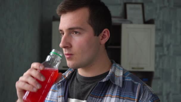Человек пьет вишневый сок в пластиковой бутылке — стоковое видео