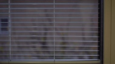 Adam banyodaki perdeleri kapatıyor.