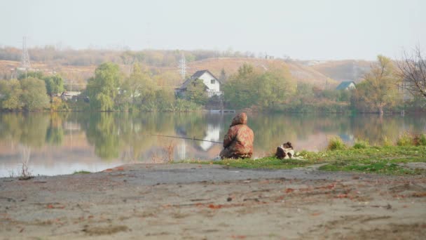 Ein Fischer, der am Ufer des Flusses fischt — Stockvideo